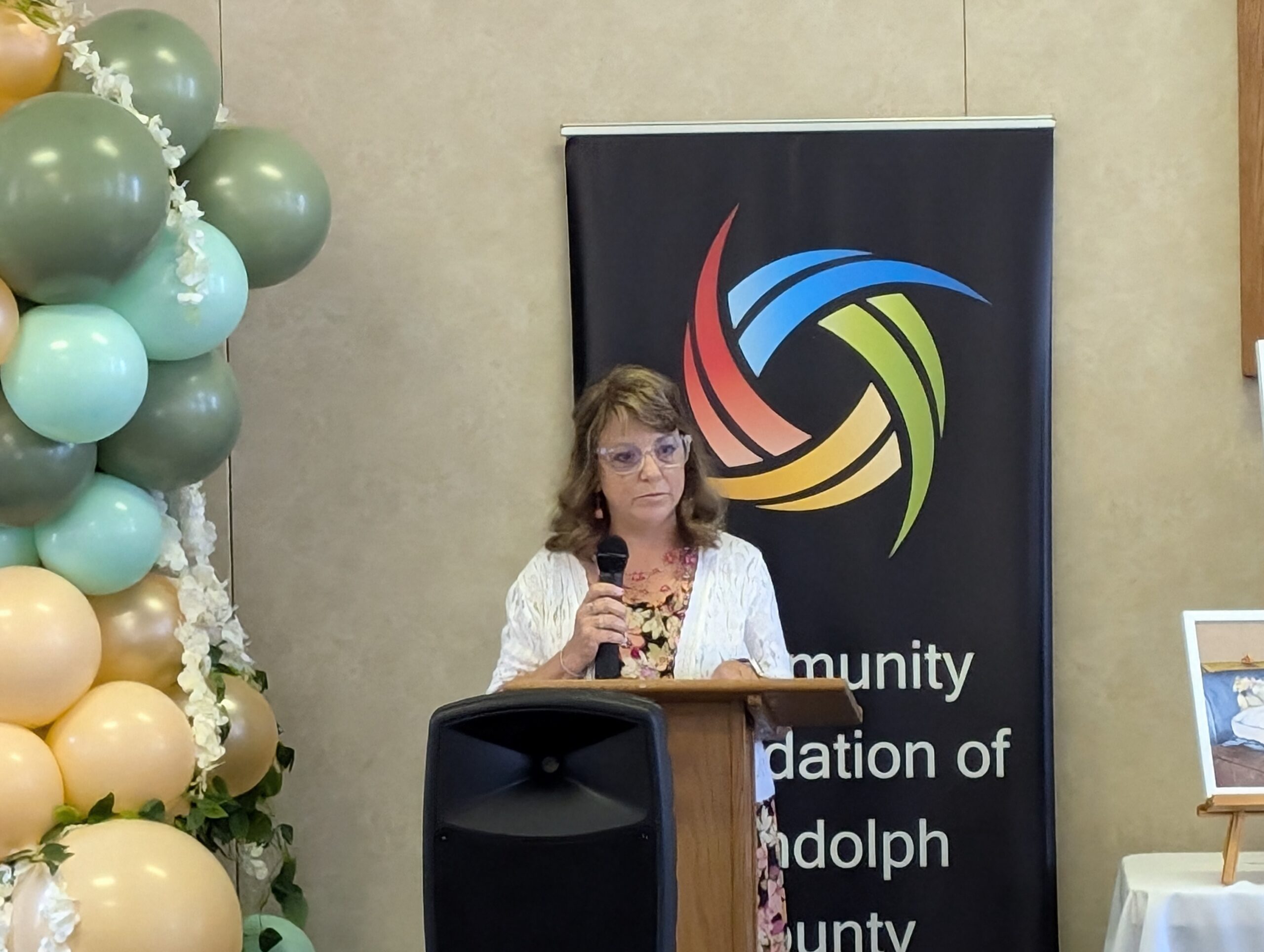 Image of Cheryl Fisher, owner of Matchett & Ward Insurance, as she speaks to Women's Fund crowd.