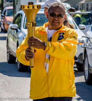 Image of a man known as Jim Nunez, Jr. holding a torch during Indiana's Bicentennial celebration.